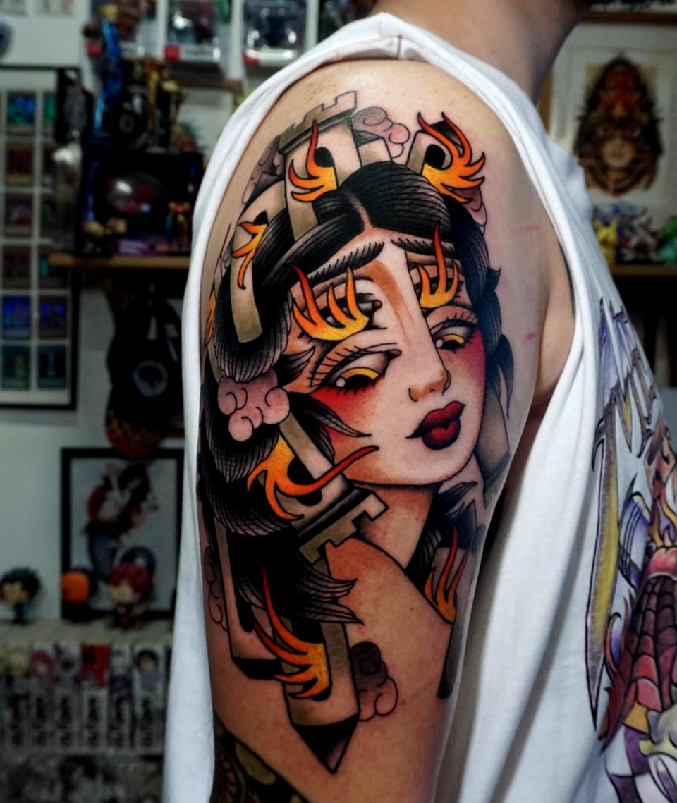 Unmistakable - Ambassadors and Artists - Malik Kleinwort - Tattoo eines brennenden Frauenkopfes mit Gebäuden auf Haar auf Oberarm
