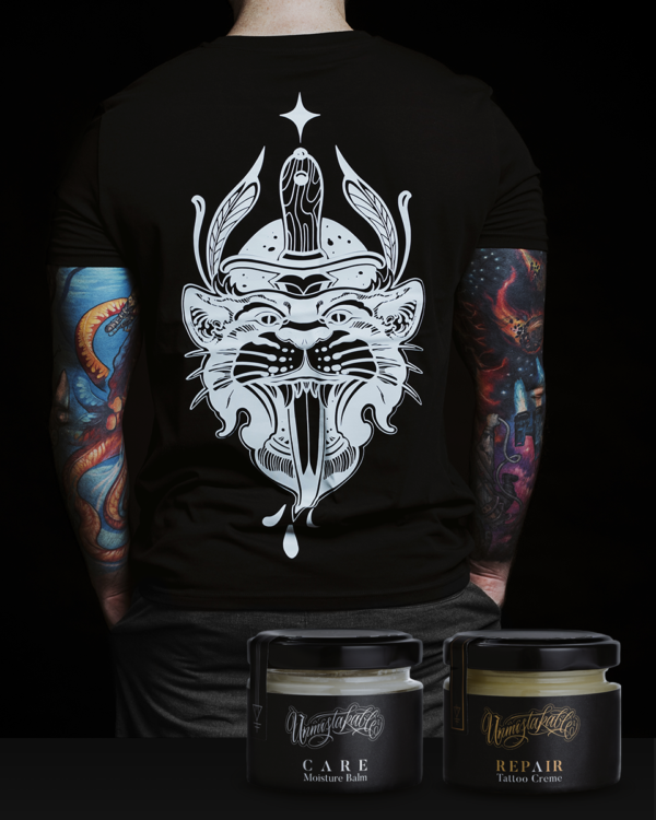 Unmistakable Dagger Thrust Box - Junger Mann mit schwarzem T-Shirt von hinten fotografiert und REPAIR Tattoo Creme und CARE Moisture Balm