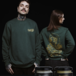 Unmistakable - Winter Wilderness Box Care Green - Mann und Frau in grünem Pulli mit Tattoos und Tattoopflegecreme-Gläser