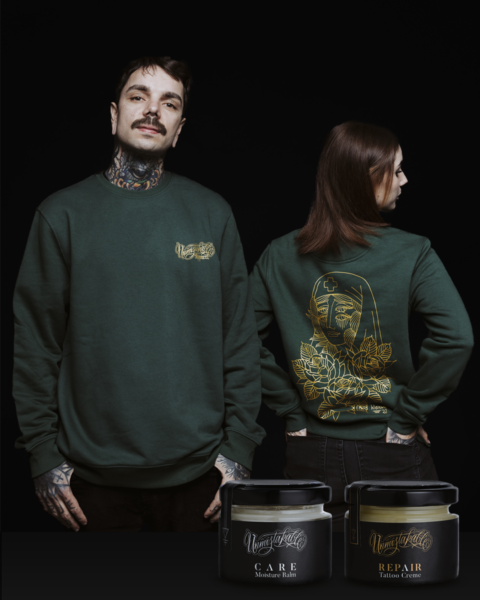 Unmistakable - Winter Wilderness Box Care Green - Mann und Frau in grünem Pulli mit Tattoos und Tattoopflegecreme-Gläser
