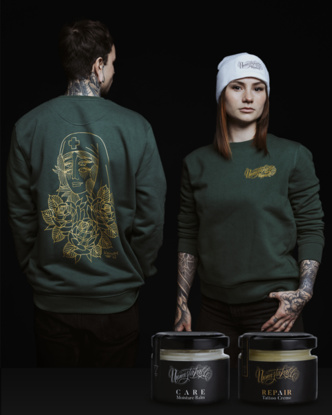 Unmistakable - Winter Wilderness Box Deluxe Green - Mann und Frau in grünem Pulli mit Tattoos und Tattoopflegecreme-Gläser