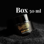 Unmistakable - Vegane Premium Tattoopflege - Repair Tattoo Creme Glas auf schwarzem Sand mit Aufschrift Box 50 ml